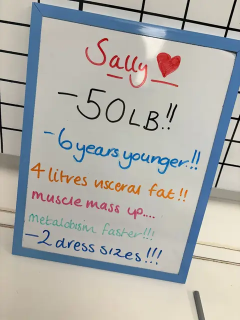 At the club, a smiling member shows the results written on her board