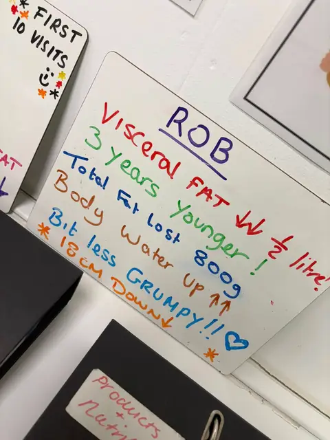 At the club, a smiling member shows the results written on his board